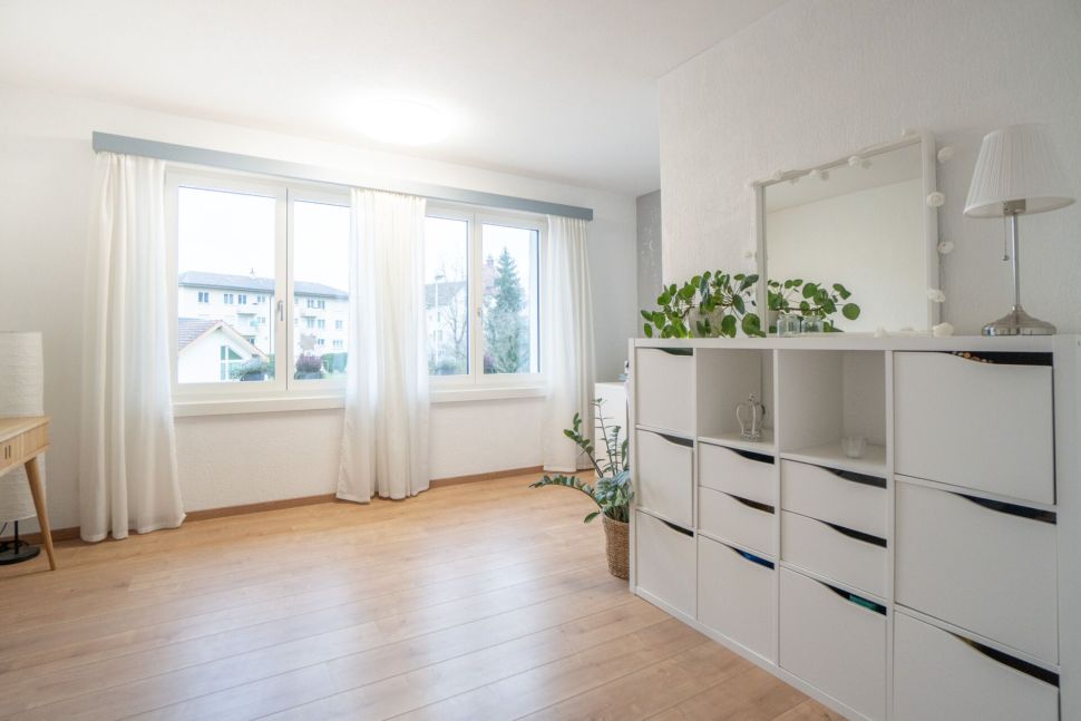 Helles Schlafzimmer mit Fensterwand und weißem Regal