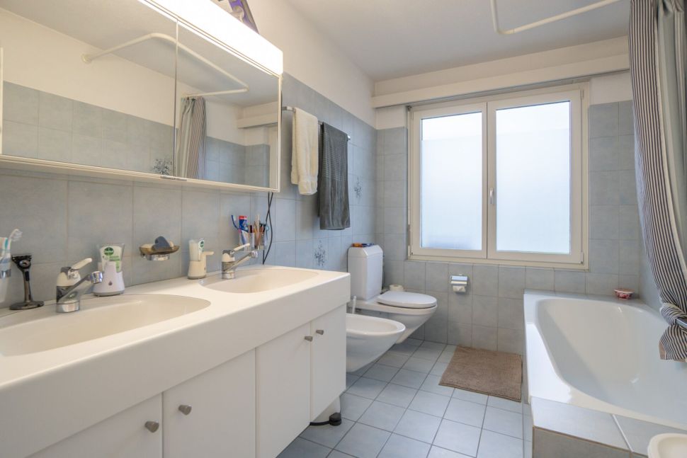 Helles Badezimmer mit Doppelwaschtisch und Badewanne