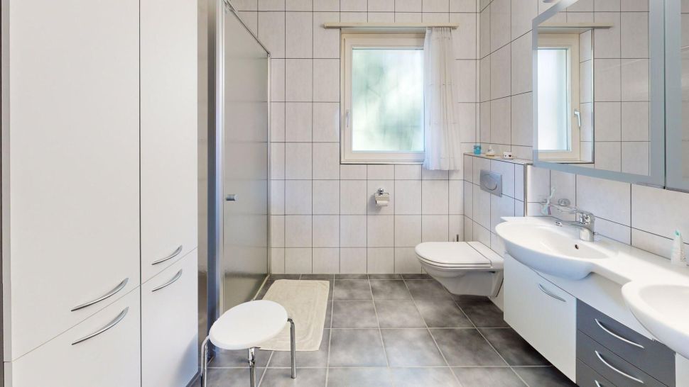 Helles, modernes Badezimmer mit Dusche, WC und Doppelwaschtisch