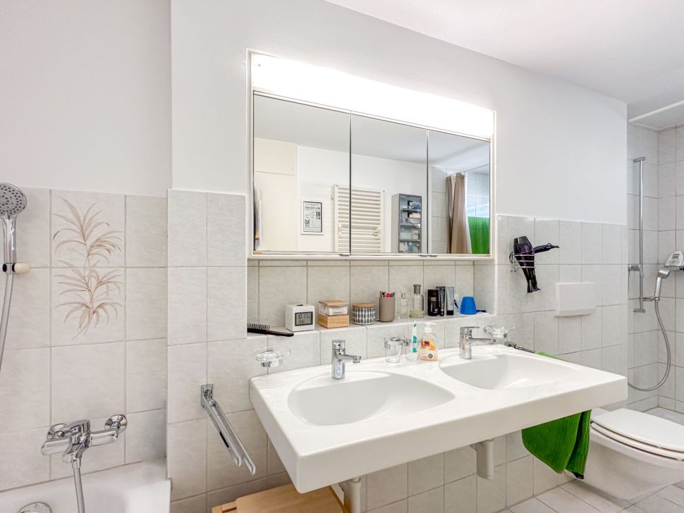 Helles Badezimmer mit Doppelwaschbecken und Dusche