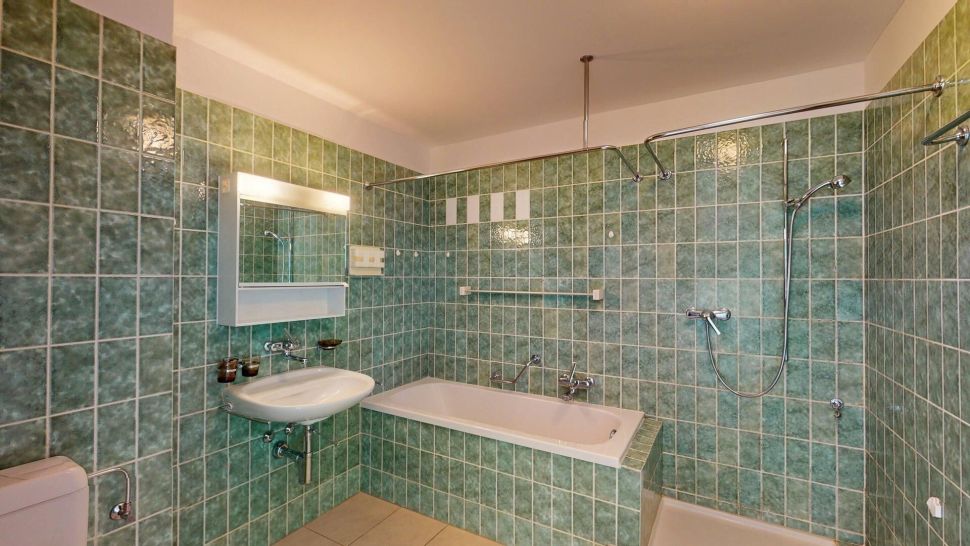 Grün gekacheltes Badezimmer mit Wanne und Dusche