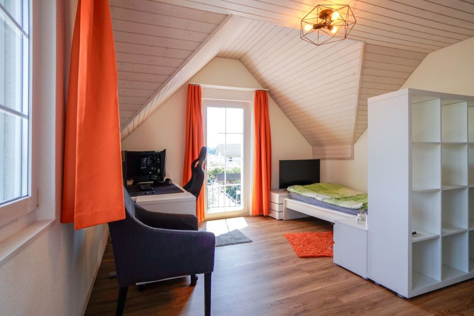 Dachzimmer mit Arbeitsplatz und Bett