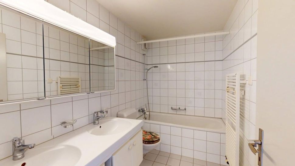 Badezimmer mit Badewanne und Doppelwaschtisch