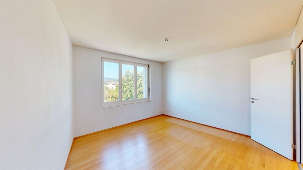 Helles, leeres Zimmer mit Holzfußboden