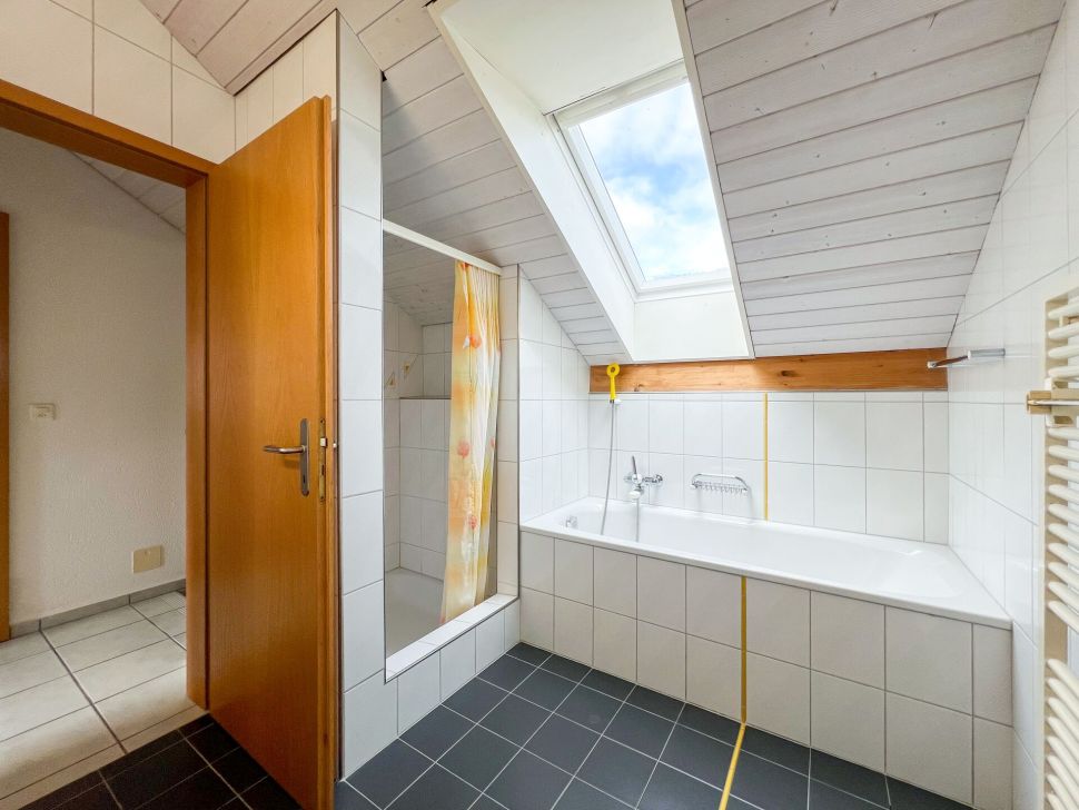 Badezimmer mit Dachfenster und Badewanne