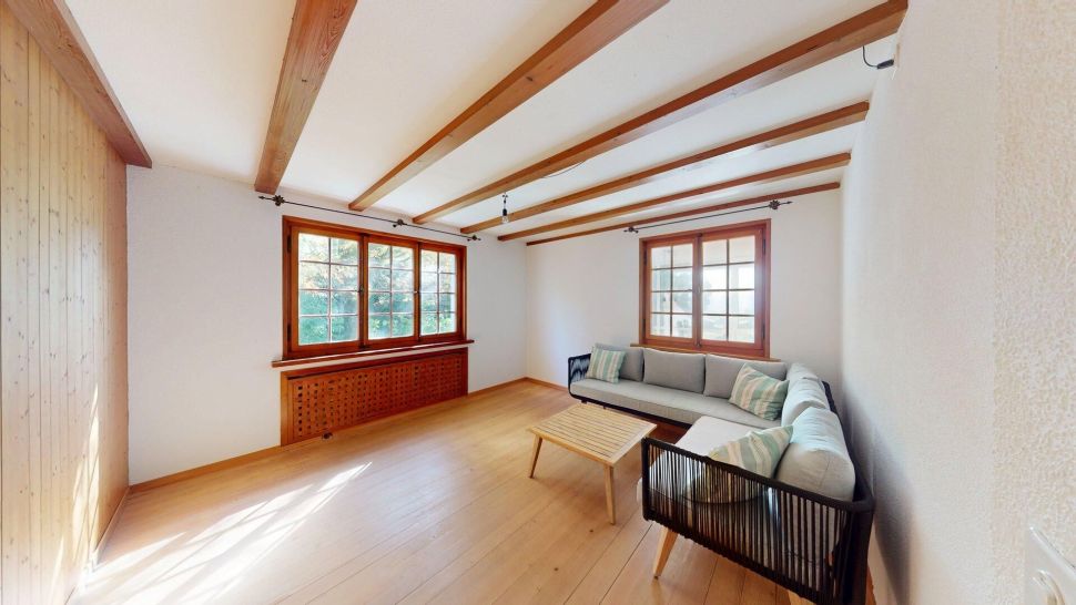 Helles Wohnzimmer mit Holzbalken und Ecksofa