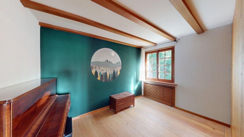 Heller kleiner Raum mit Holzdecke und grüner Akzentwand