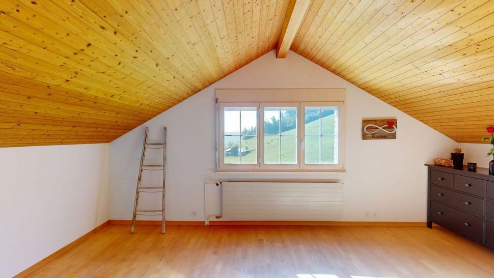 Dachzimmer mit Fenster und Holzdecke