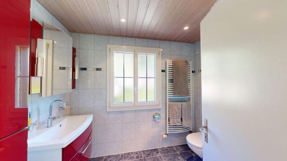 Badezimmer mit rotem Waschtisch und Fenster