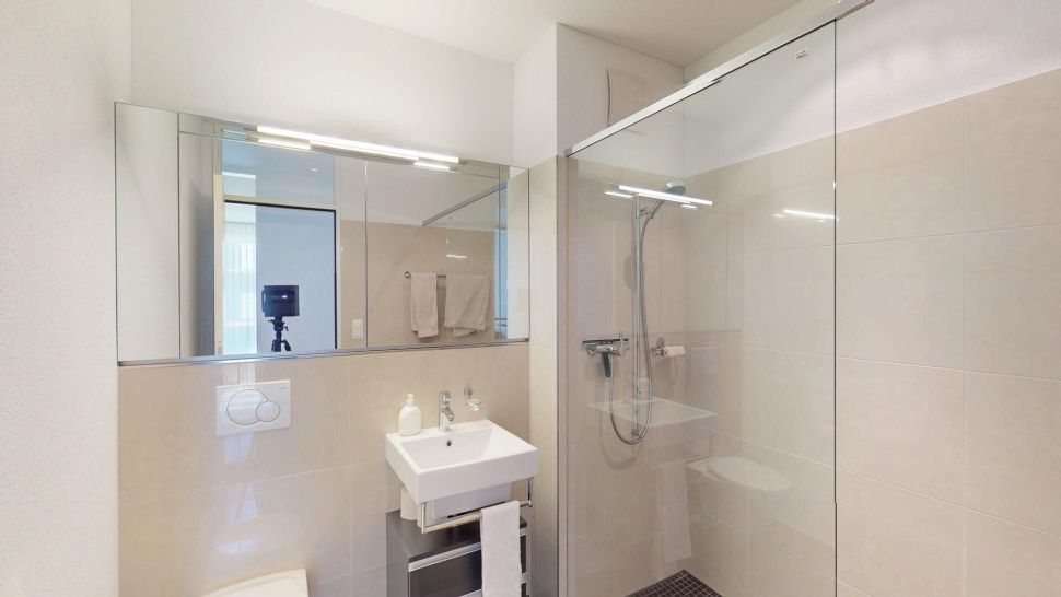 Modernes Badezimmer mit Glasdusche und Wandwaschbecken