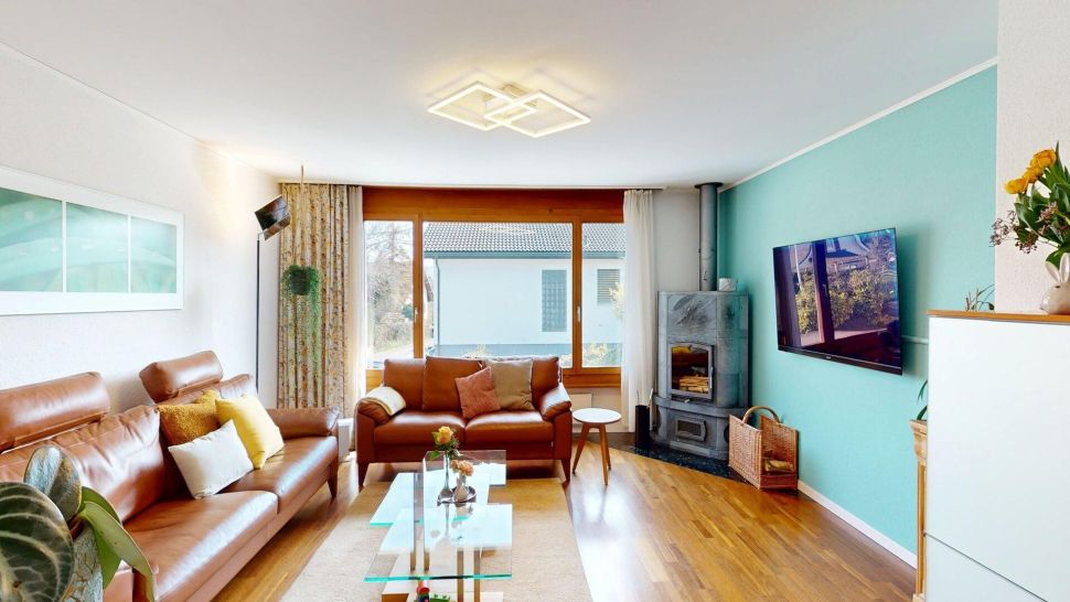 Wohnzimmer mit Kamin und großer Fensterfront