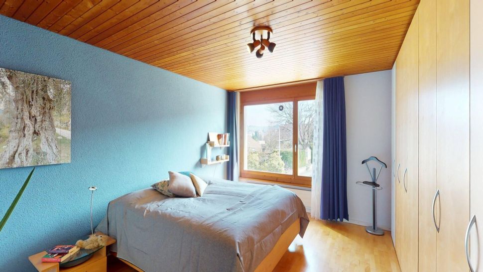 Schlafzimmer mit Holzdecke und großem Fenster