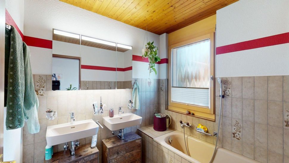 Badezimmer mit Doppelwaschtisch und Badewanne