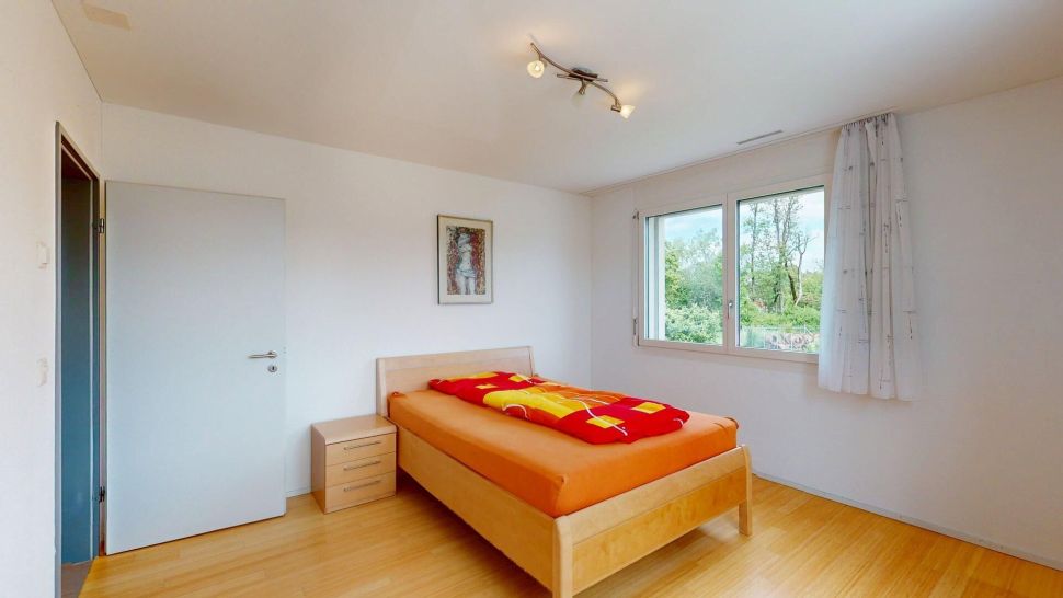 Helles Schlafzimmer mit Einzelbett und Fensterblick