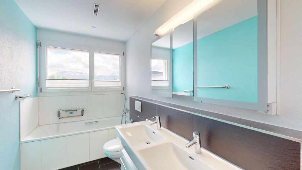 Helles Badezimmer mit Badewanne und Doppelwaschtisch