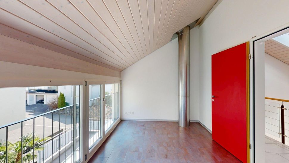 Lichtdurchflutete Galerie mit roter Tür