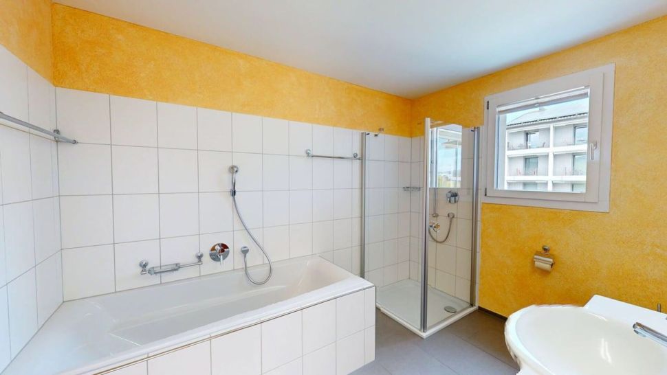 Badezimmer mit Badewanne und Dusche