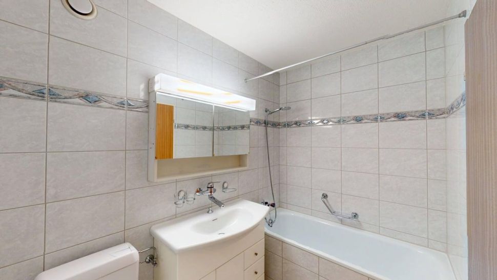 Badezimmer mit Wanne und Spiegelschrank