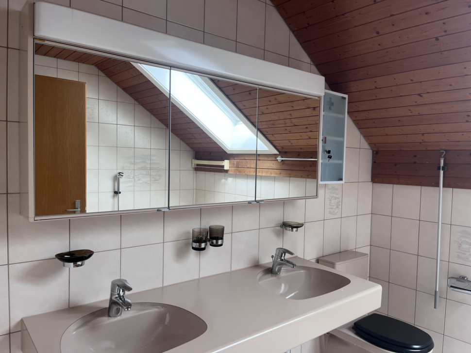 Badezimmer mit Doppelwaschtisch und Dachfenster