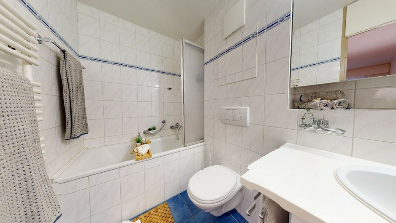 Kleines, helles Badezimmer mit Badewanne und WC