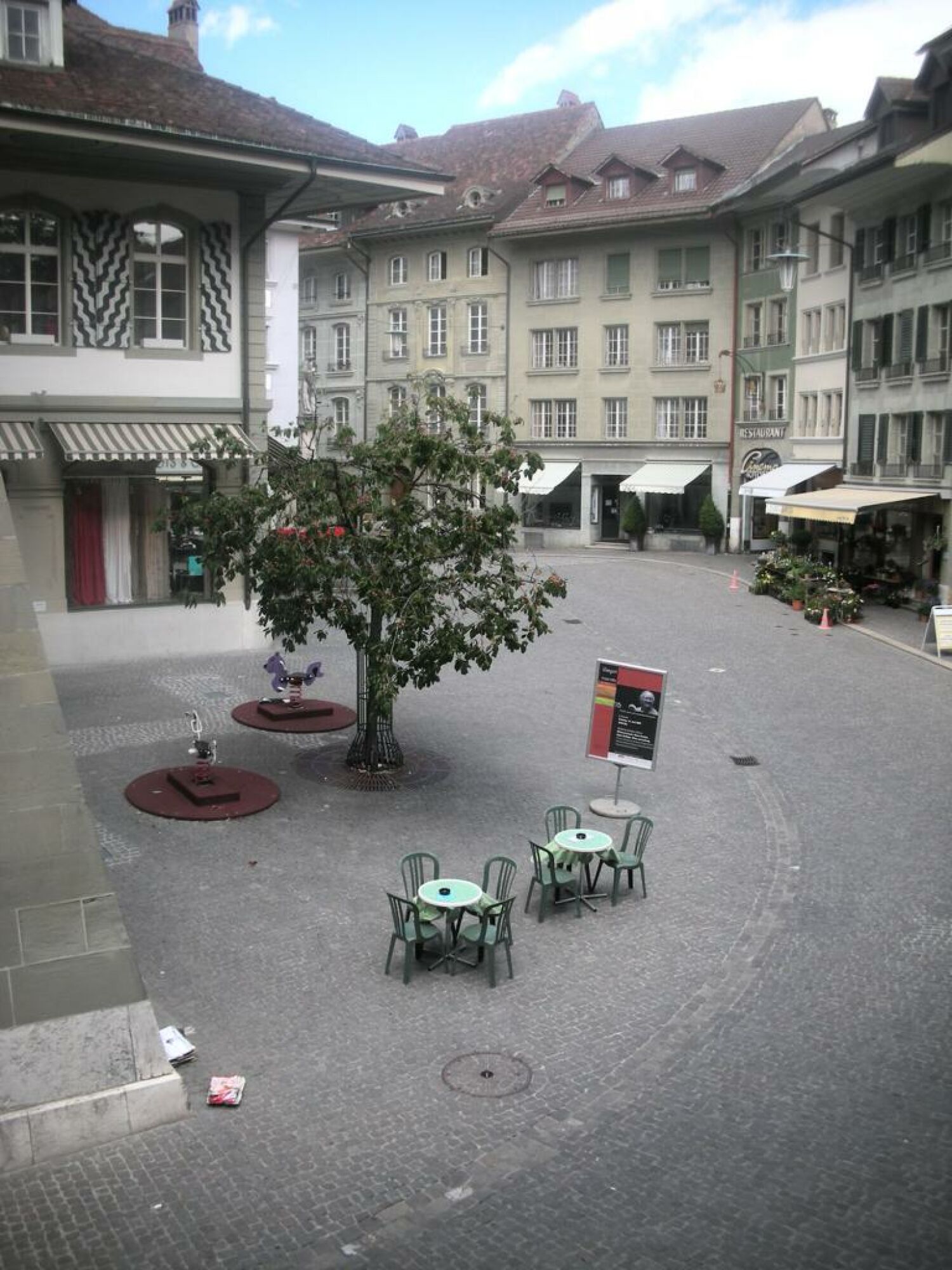 Innenhof mit historischen Gebäuden und Café-Sitzbereich
