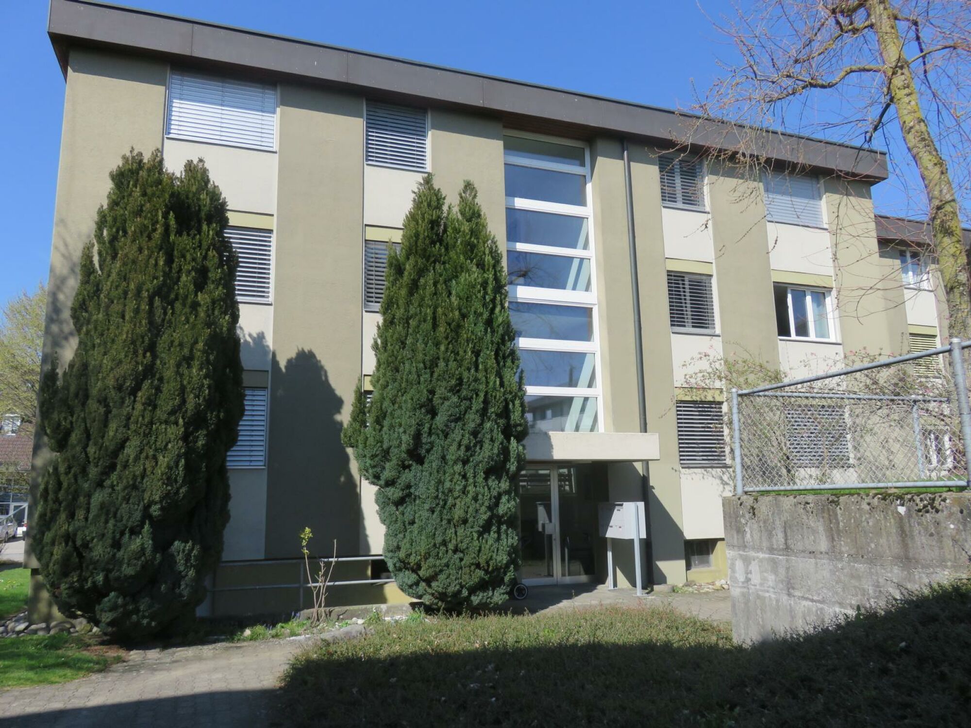Modernes Mehrfamilienhaus mit umlaufenden Fenstern