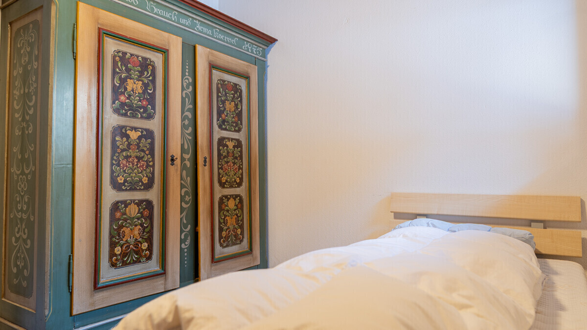 Schlafzimmer mit bemaltem Kleiderschrank