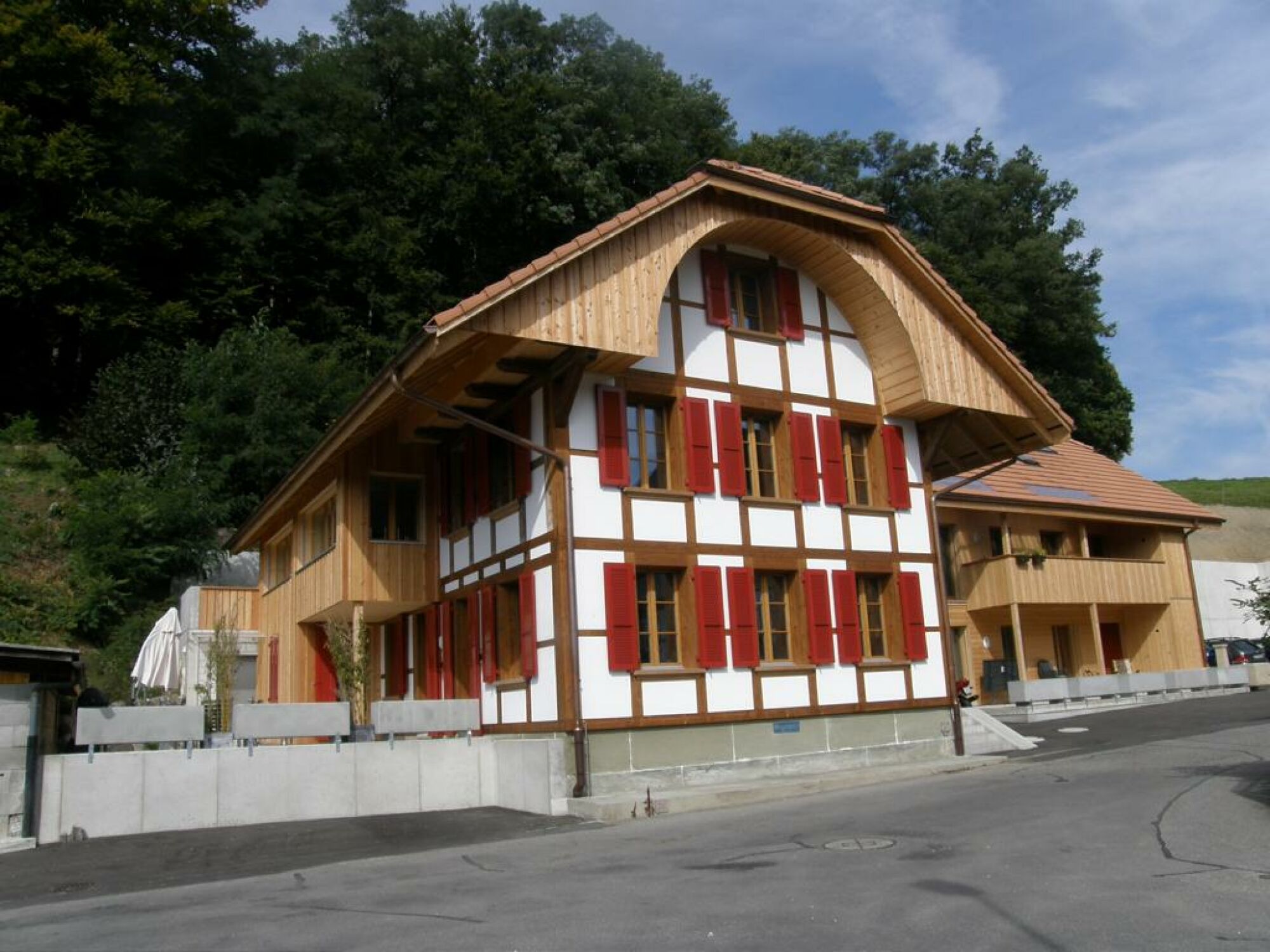 Traditionelles Holzhaus mit roter Fensterlaibung