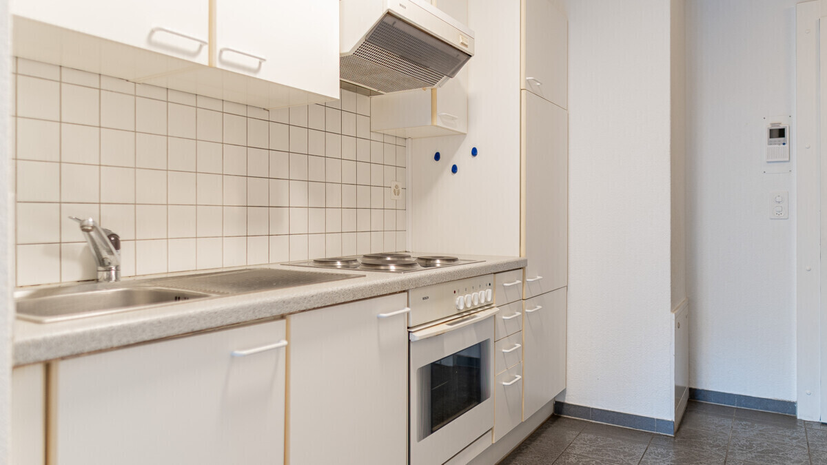 Kleine helle Küche mit weißen Fronten