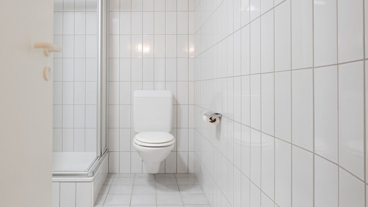 Kleines weiß gefliestes Bad mit WC