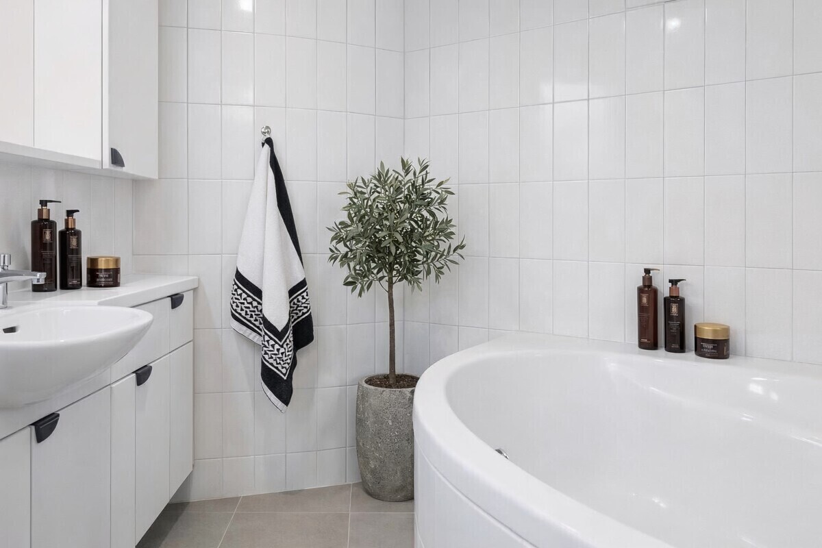 Modernes Badezimmer mit Badewanne und Pflanzenakzent