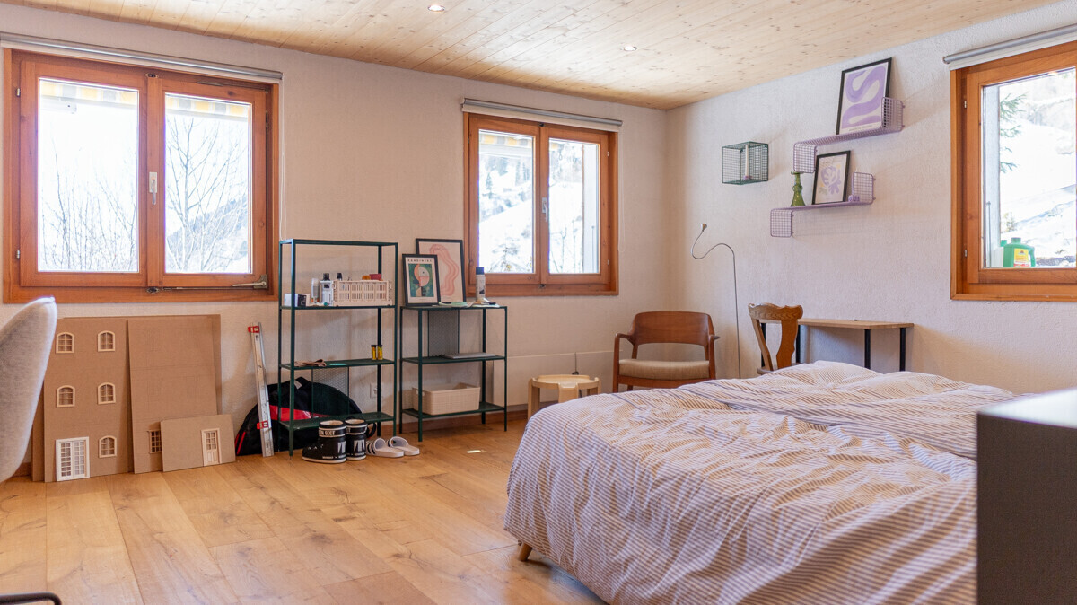 Helles Schlafzimmer mit Holzfenstern und Naturholzboden