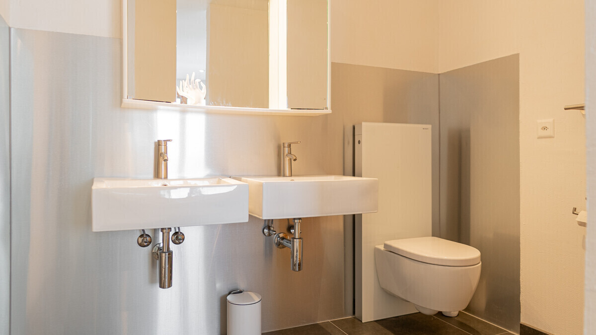 Gäste-WC mit Doppelwaschbecken und wandhängendem WC
