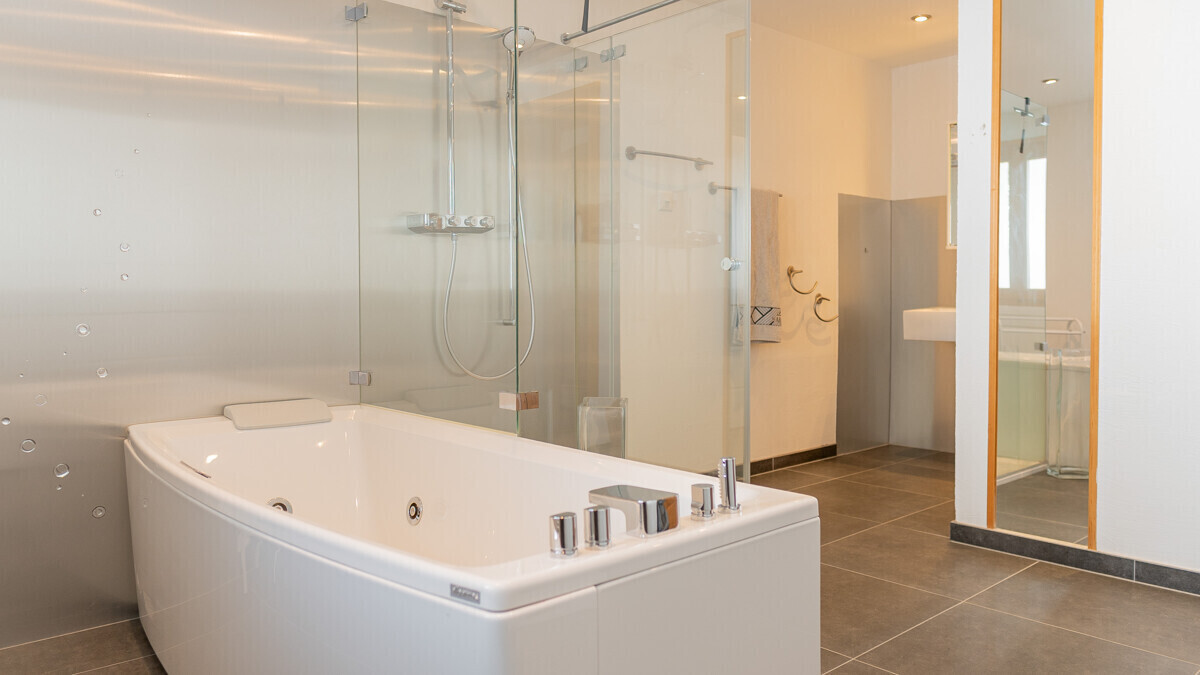 Modernes Badezimmer mit Whirlpoolwanne und Glasdusche