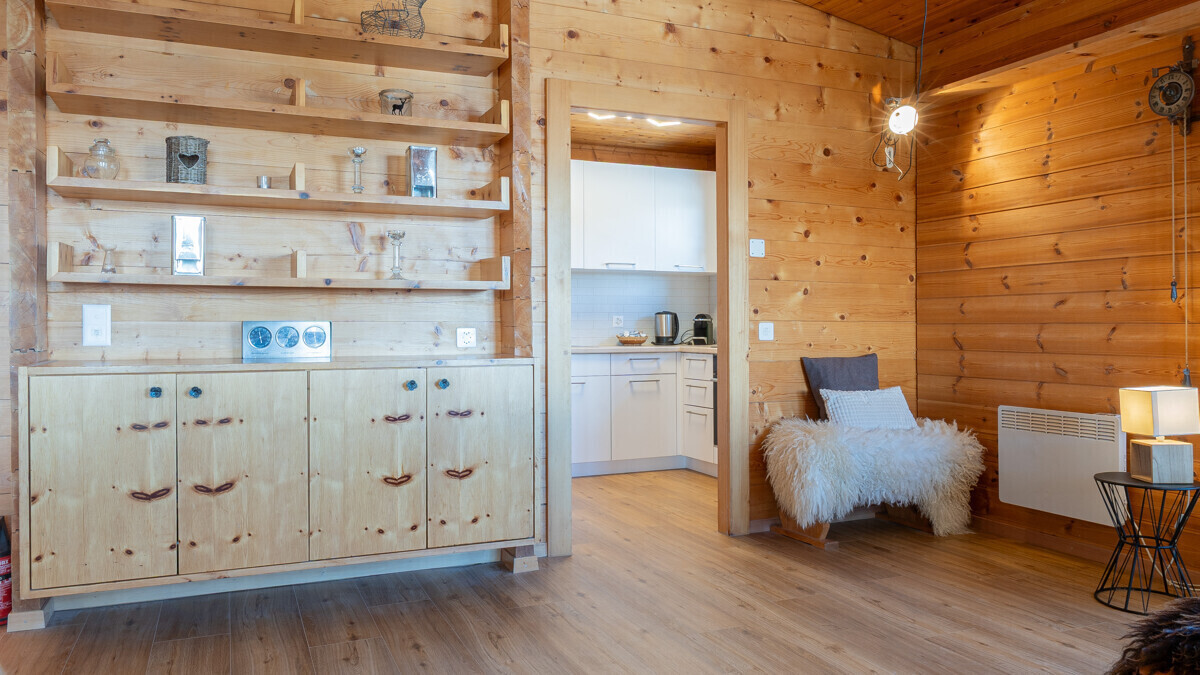 Holzvertäfelter Wohnraum mit Durchgang zur Küche