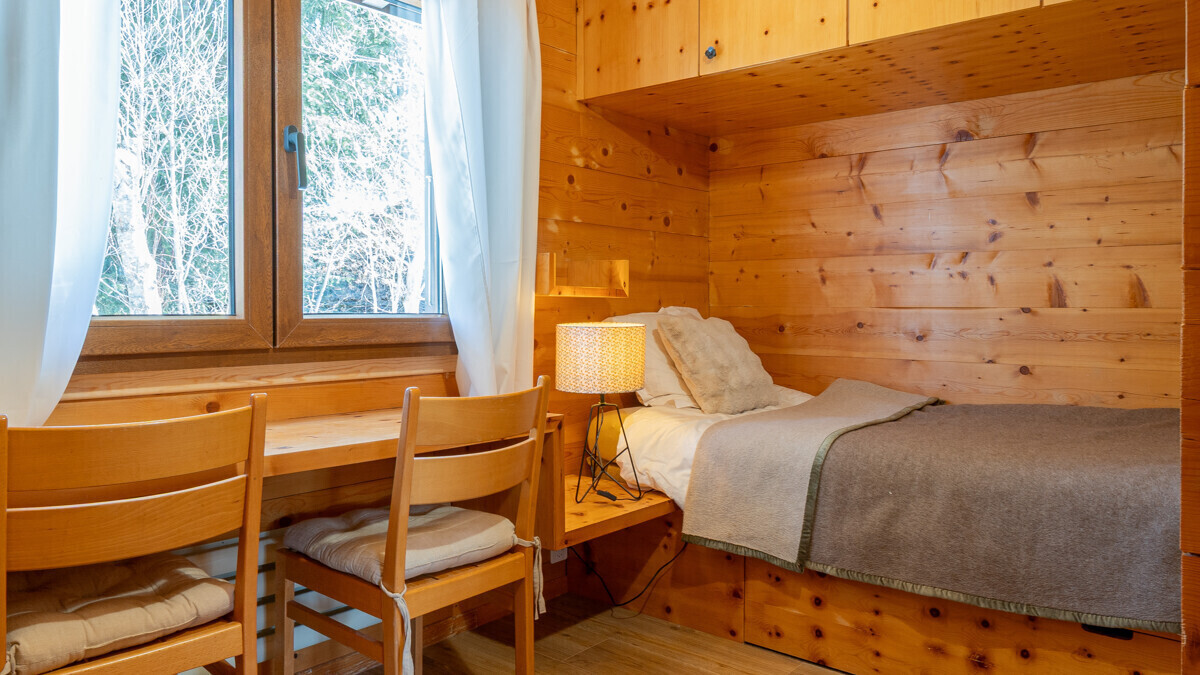 Gemütliches Holz-Schlafzimmer mit Fenster und Einzelbett