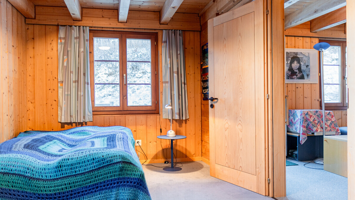 Gemütliches Holzschlafzimmer mit Blick ins Nebenraum