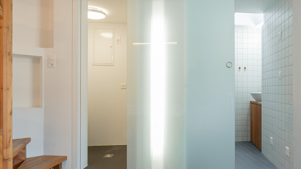 Heller Flur mit Blick in ein kleines Bad