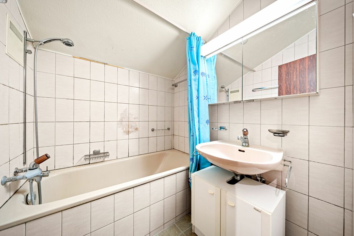 Badezimmer mit Wanne und Waschplatz