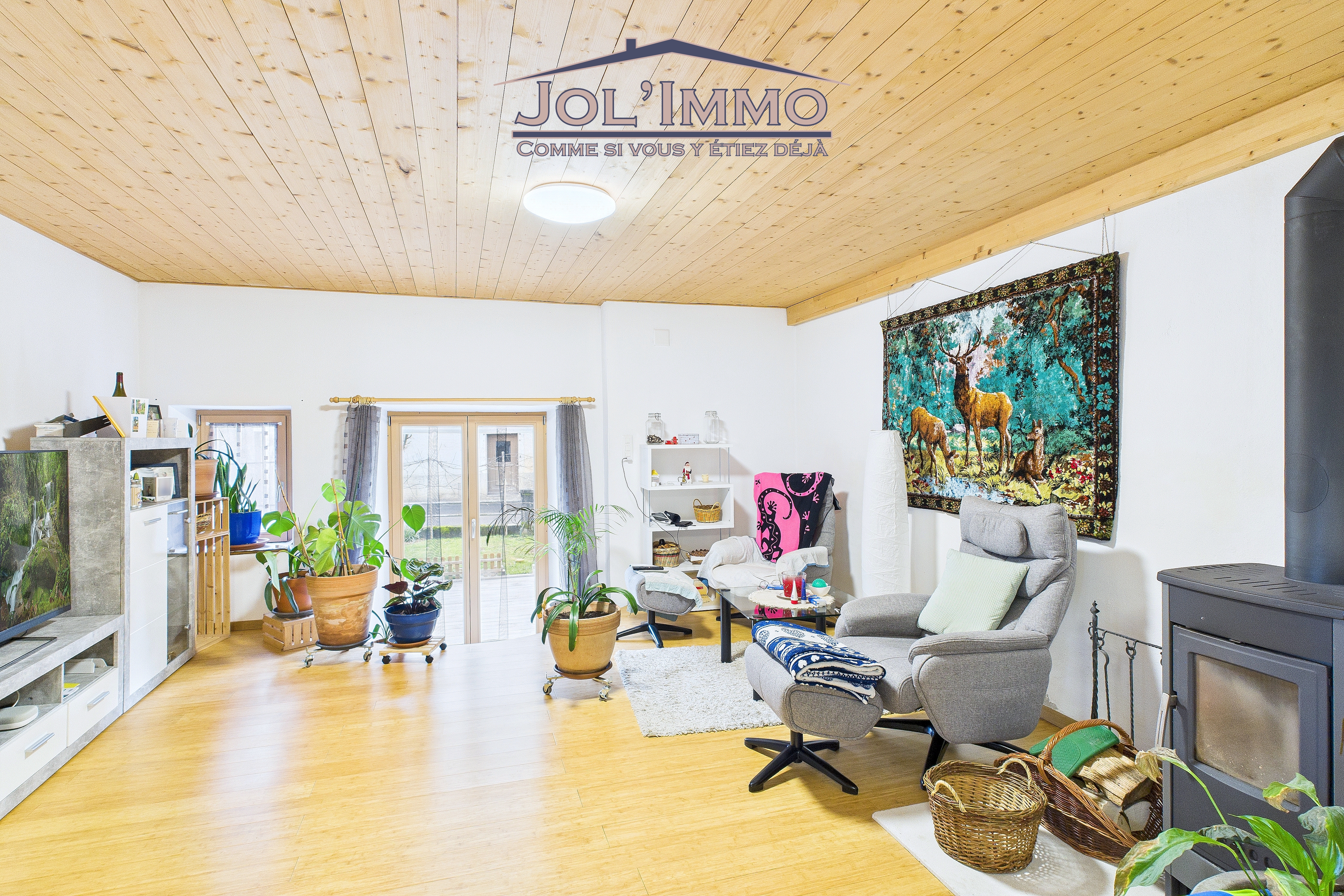 Gemütliches Wohnzimmer mit Holzdecke und Kamin