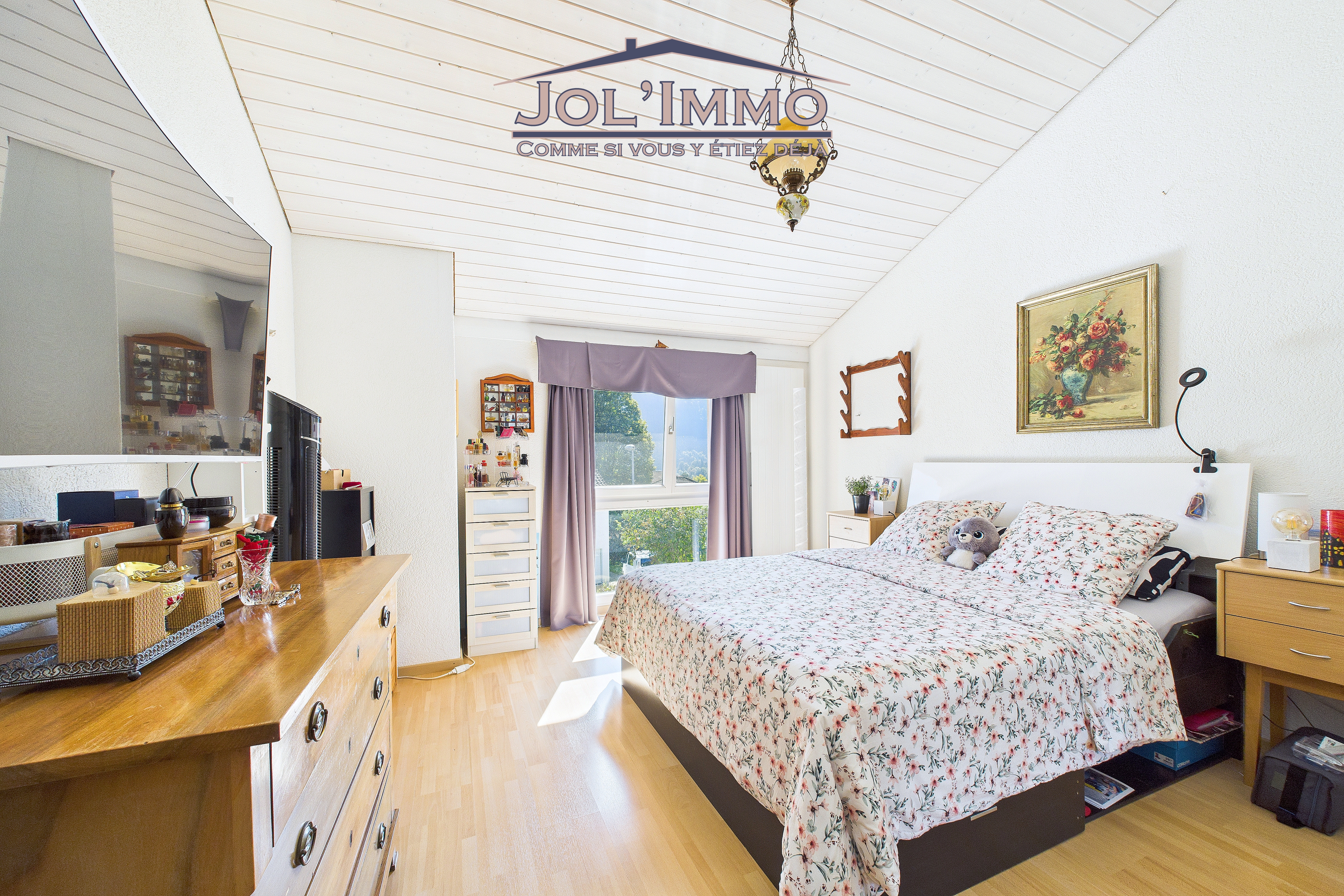 Schlafzimmer mit Dachschräge und Fensterblick