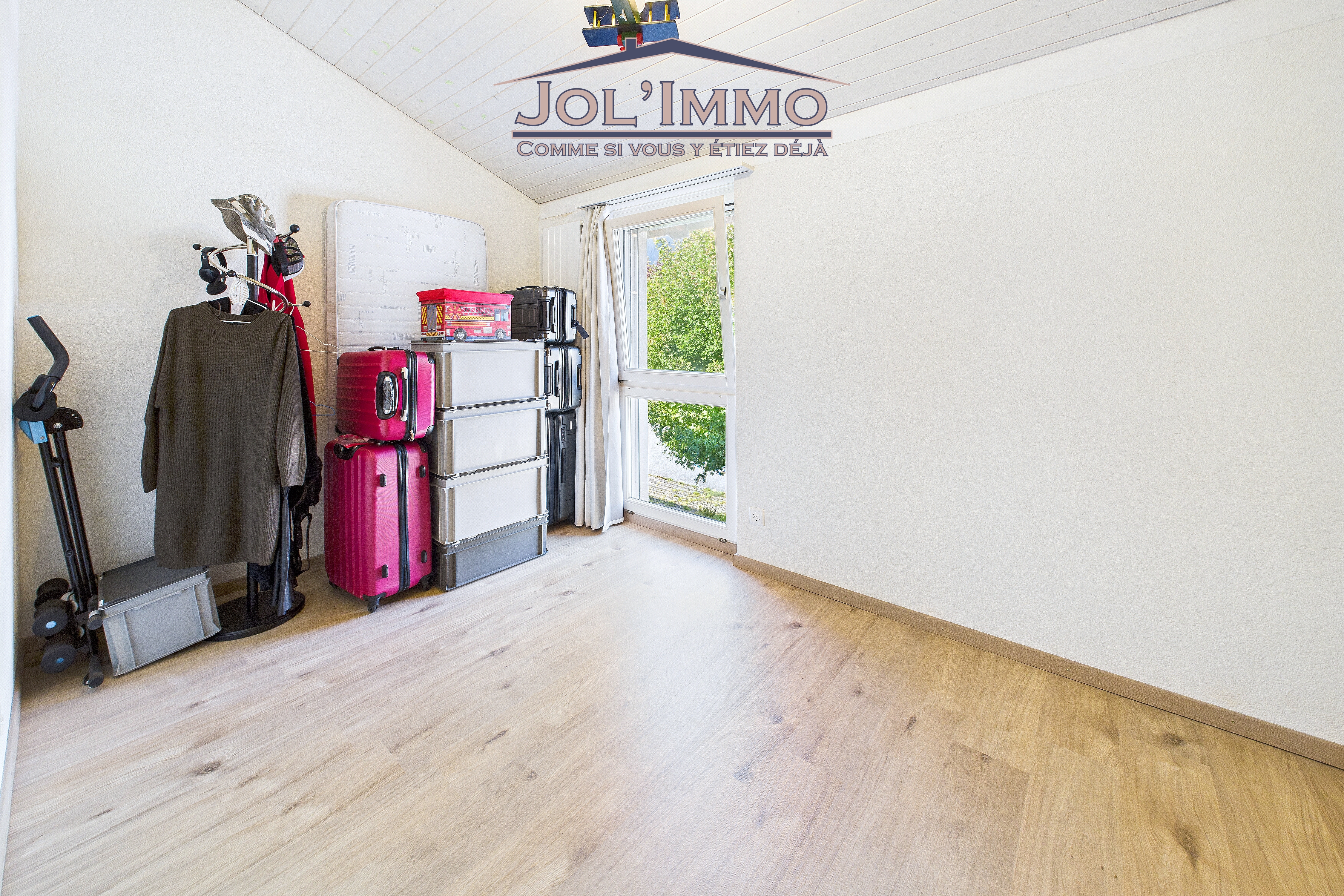 Kleines Zimmer mit Dachschräge und Fenster