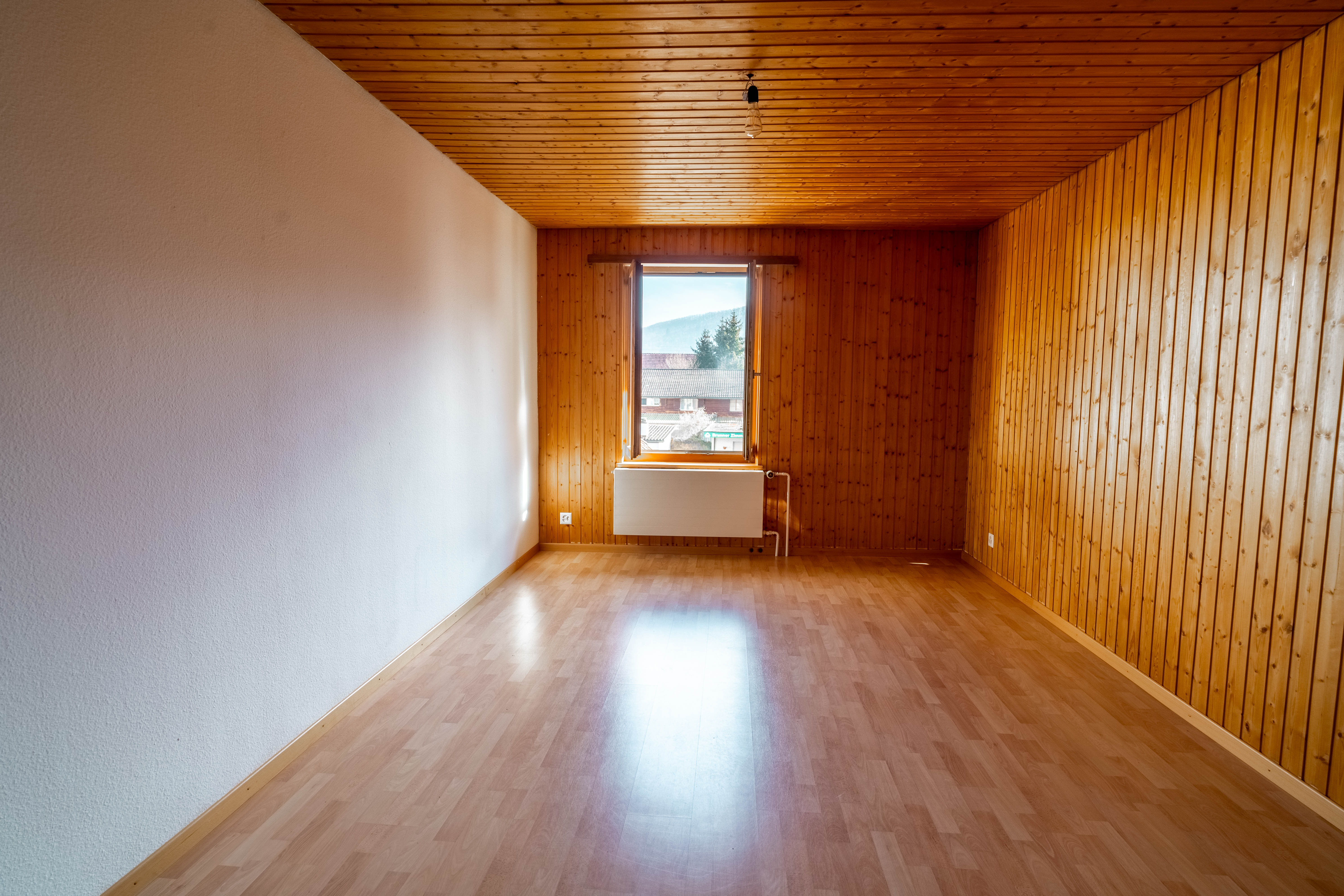 Leerer Raum mit Holzverkleidung und Fenster