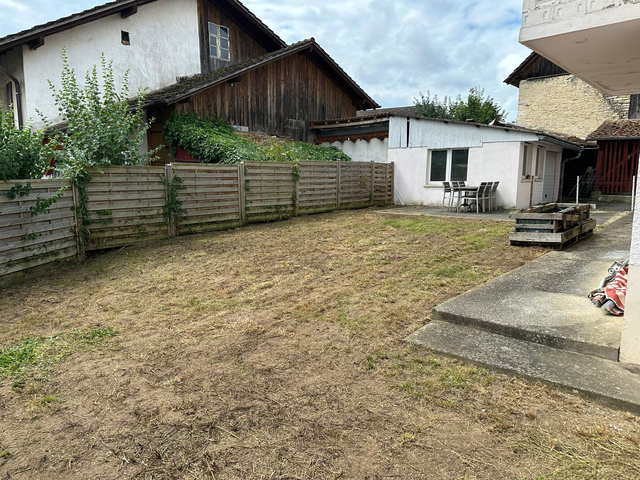 Unordentlicher Innenhof mit Garten und Nebengebäuden