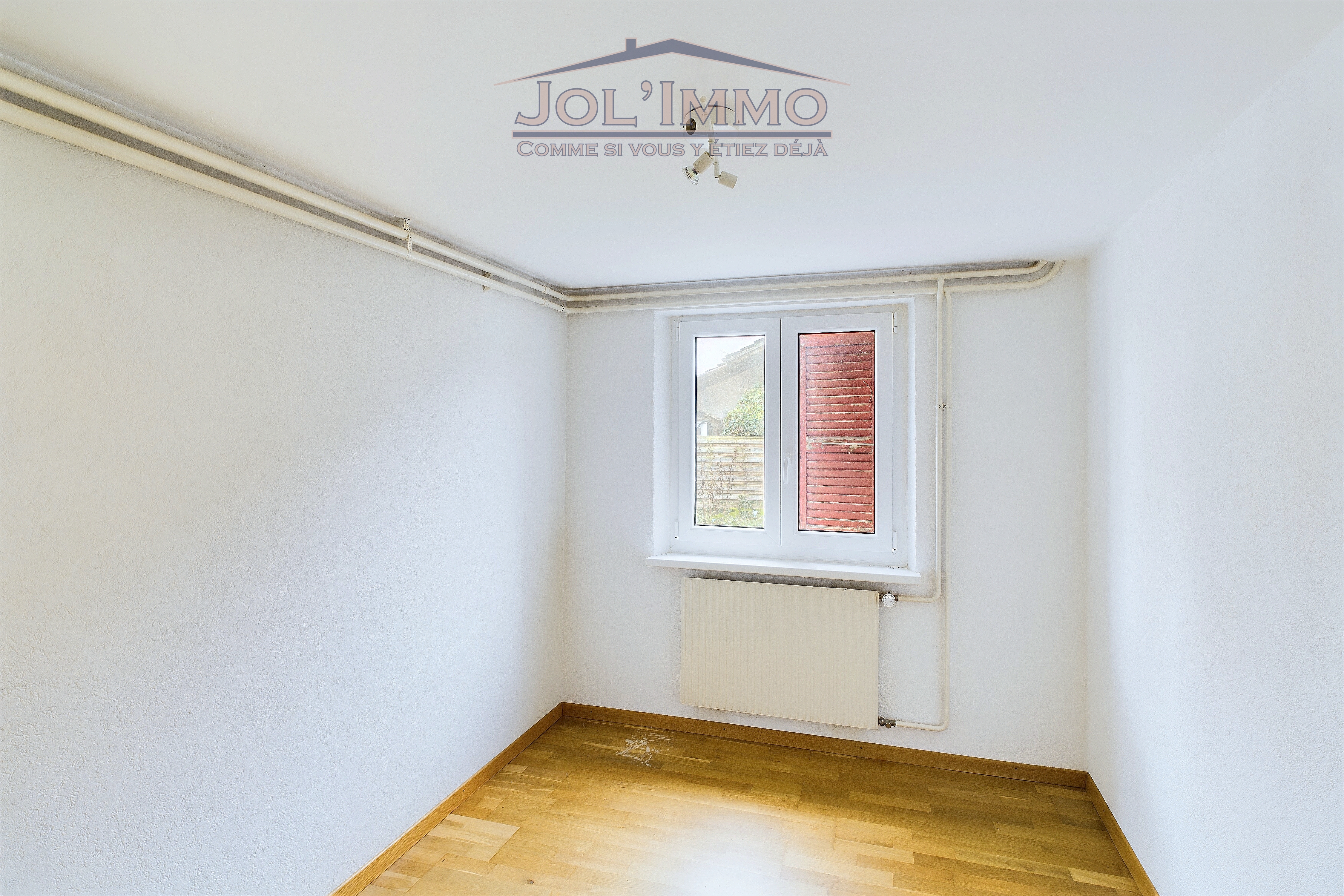 Leerer heller Raum mit Fenster und Heizkörper