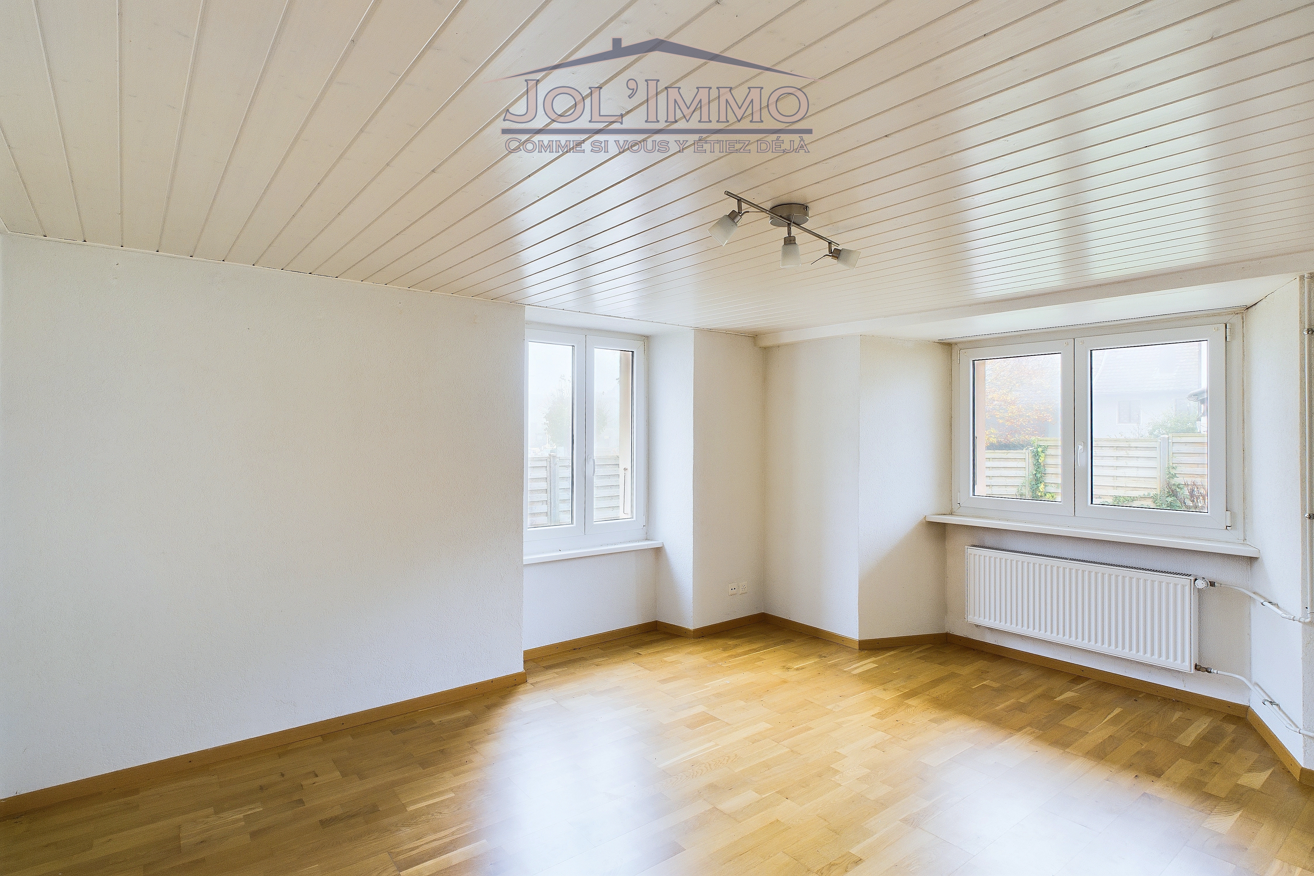 Heller leerer Raum mit Fenstern und Parkett