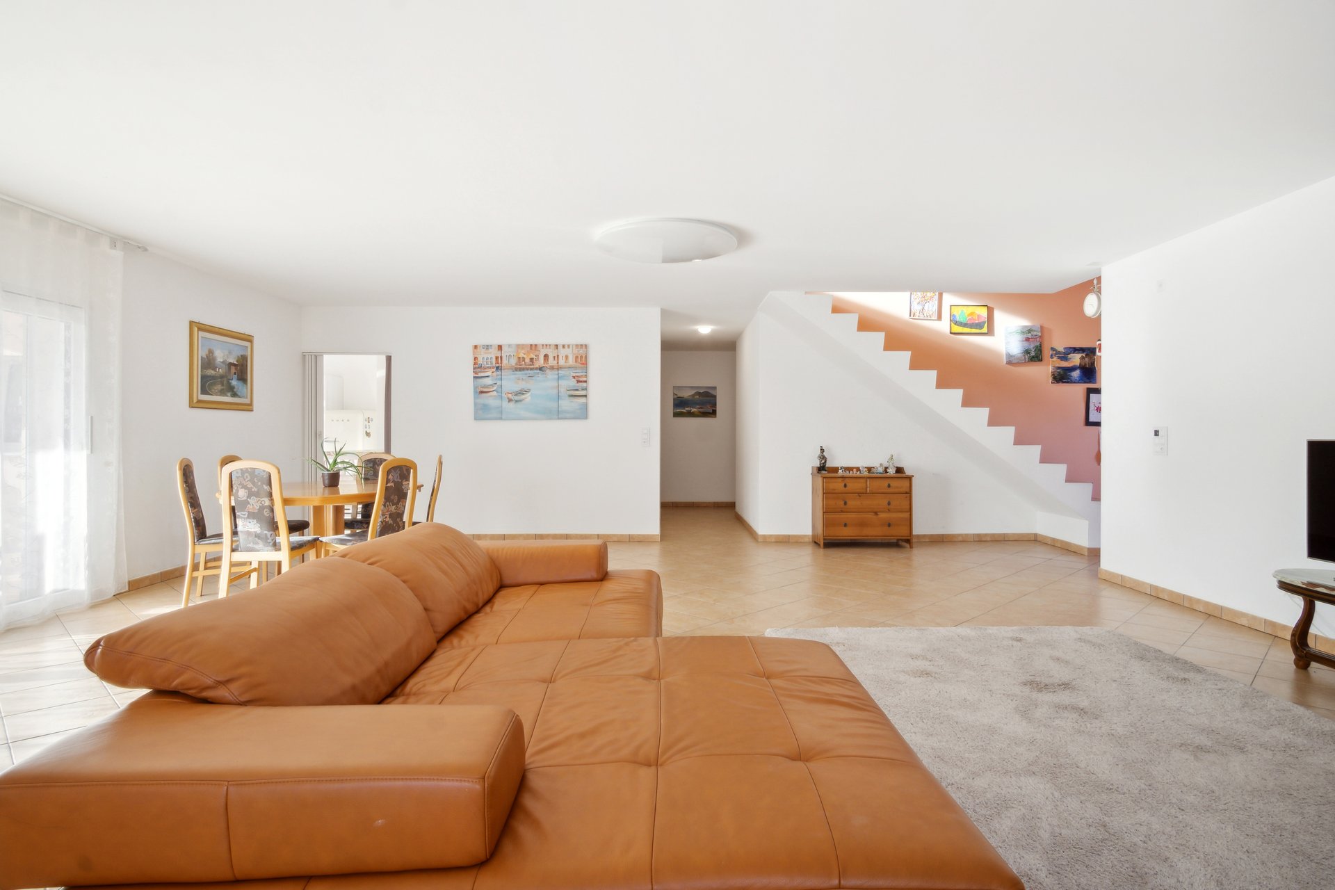 Helles Wohnzimmer mit Essbereich und Treppe