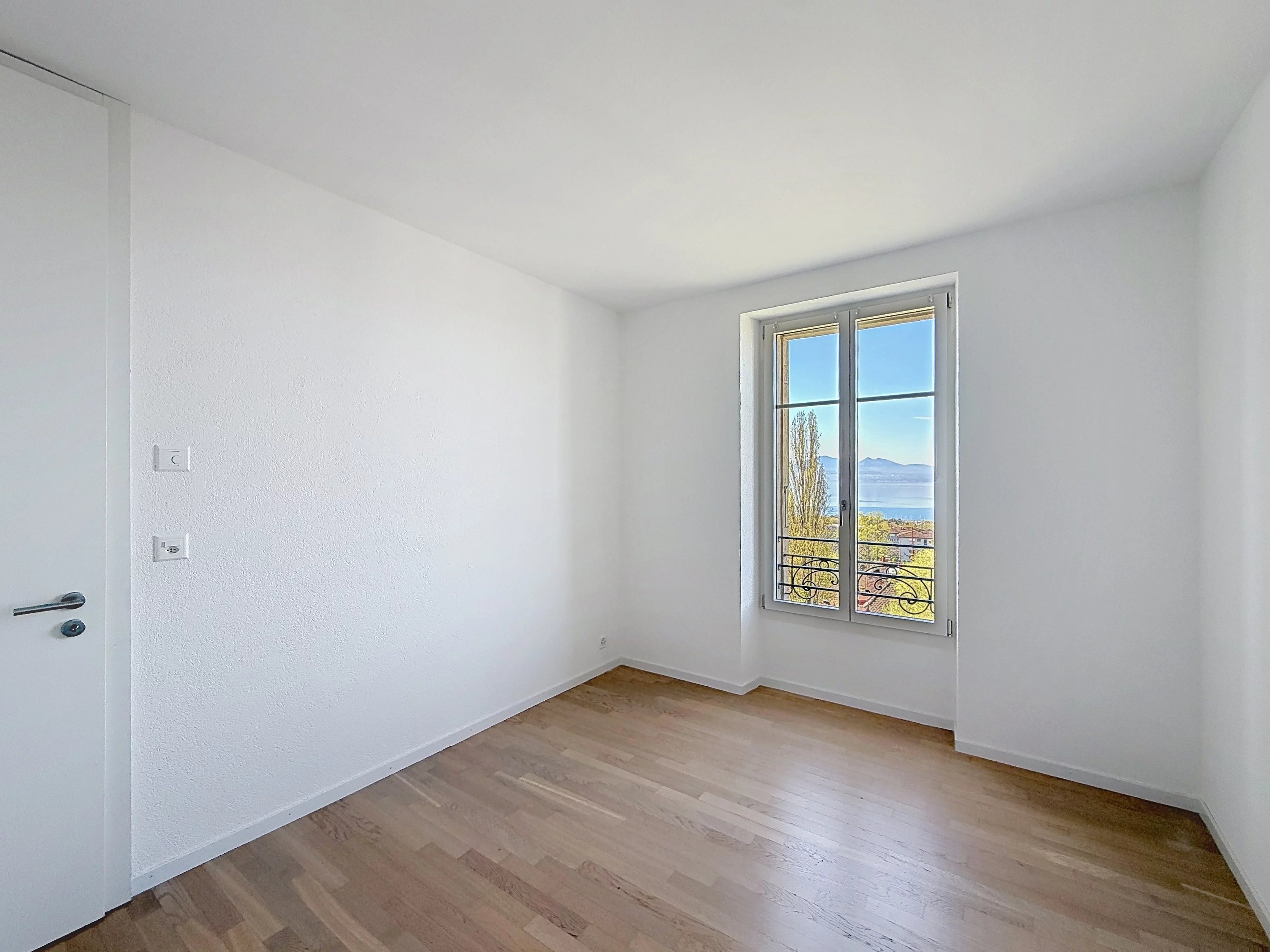 Helles, leeres Zimmer mit Fensterblick