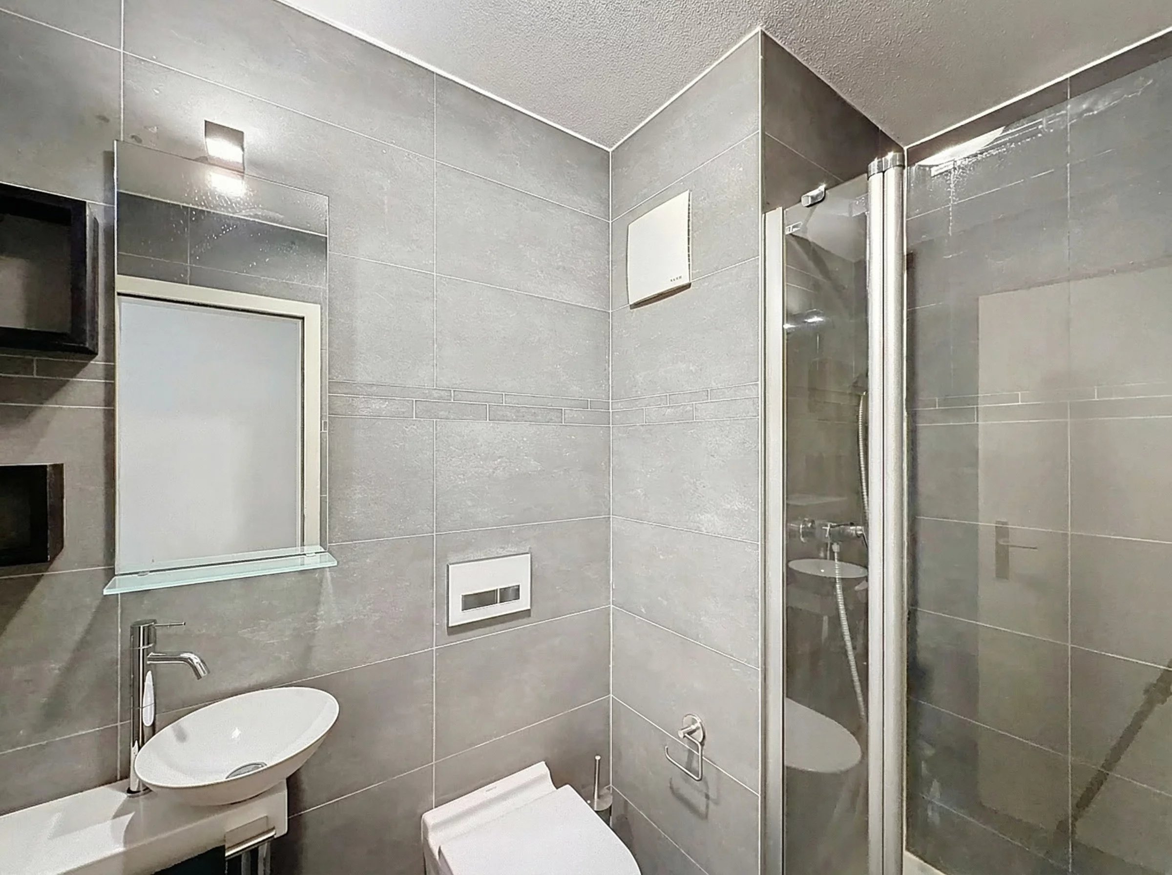 Modernes Badezimmer mit grauen Fliesen