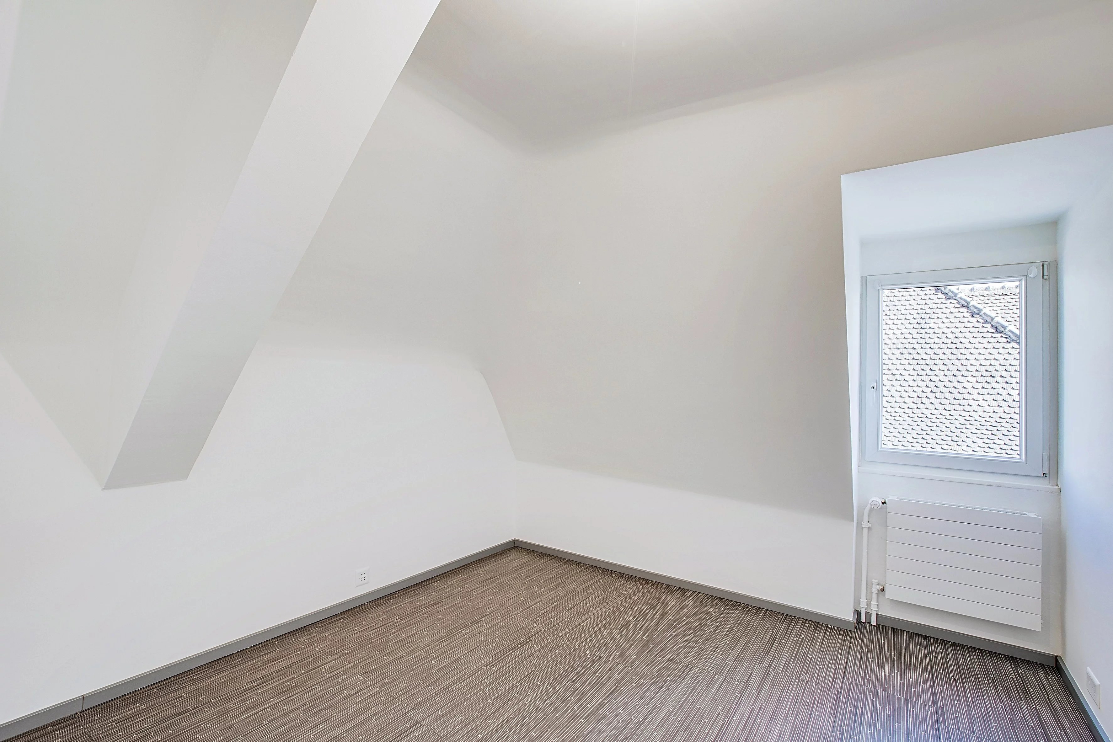 Leerer Dachgeschossraum mit schrägen Wänden